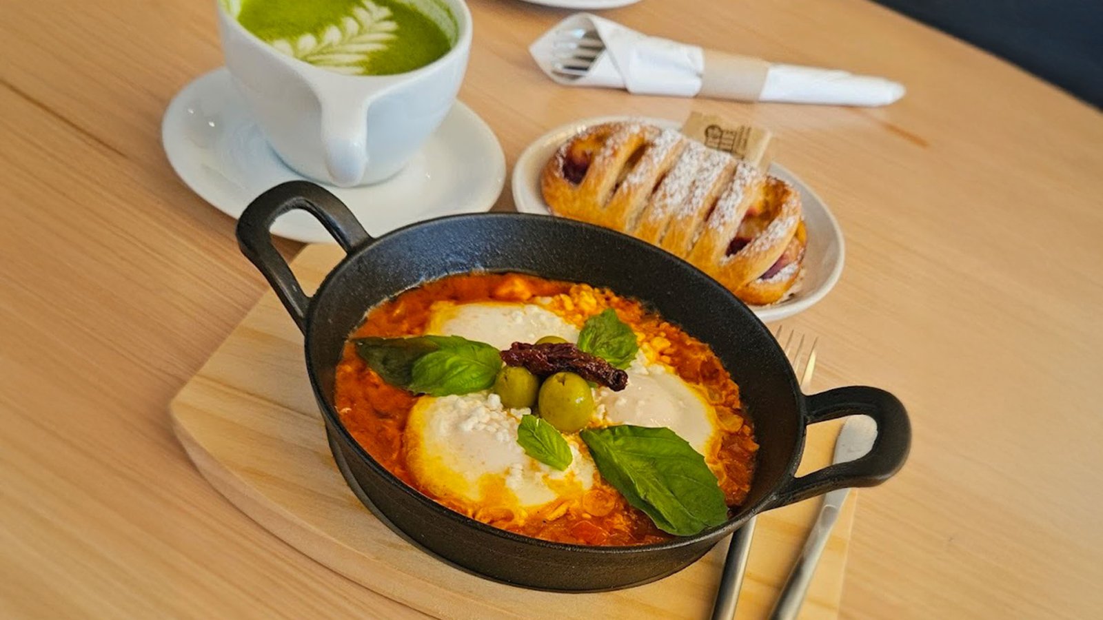 Shakshuka in a cast iron pan with a berry pastry